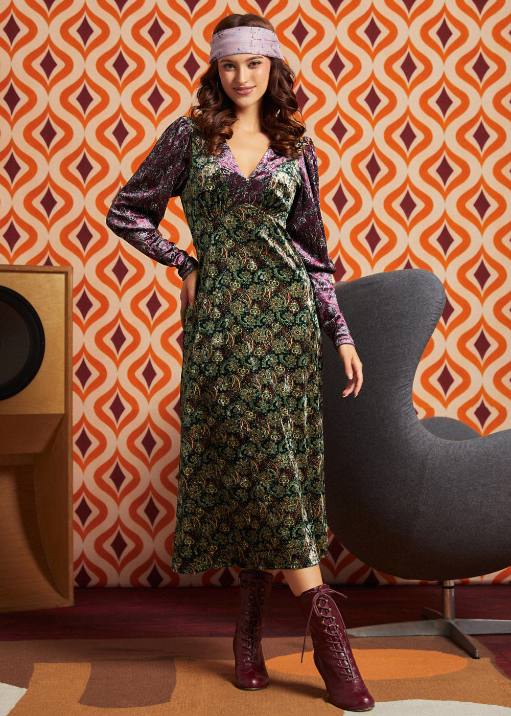 Woman wearing green and burgundy mixed paisley midi dress with burgundy lace-up boots, full front view