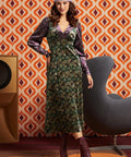 Woman wearing green and burgundy mixed paisley midi dress with burgundy lace-up boots, full front view