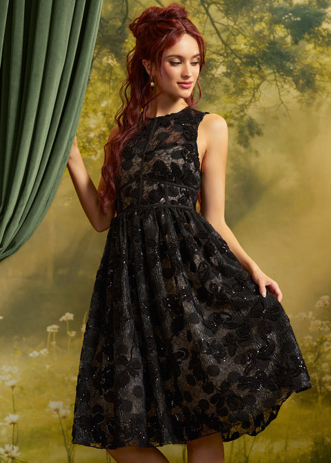 Front view of The Estelle Sequin Fit & Flare Dress in Black Dahlia, featuring black floral lace, sparkling sequins, a fitted sleeveless bodice, and a full midi skirt.