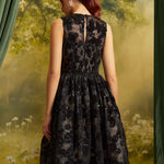 Back view of The Estelle Sequin Fit & Flare Dress showing the sleeveless bodice, defined waist, and full black lace midi skirt.