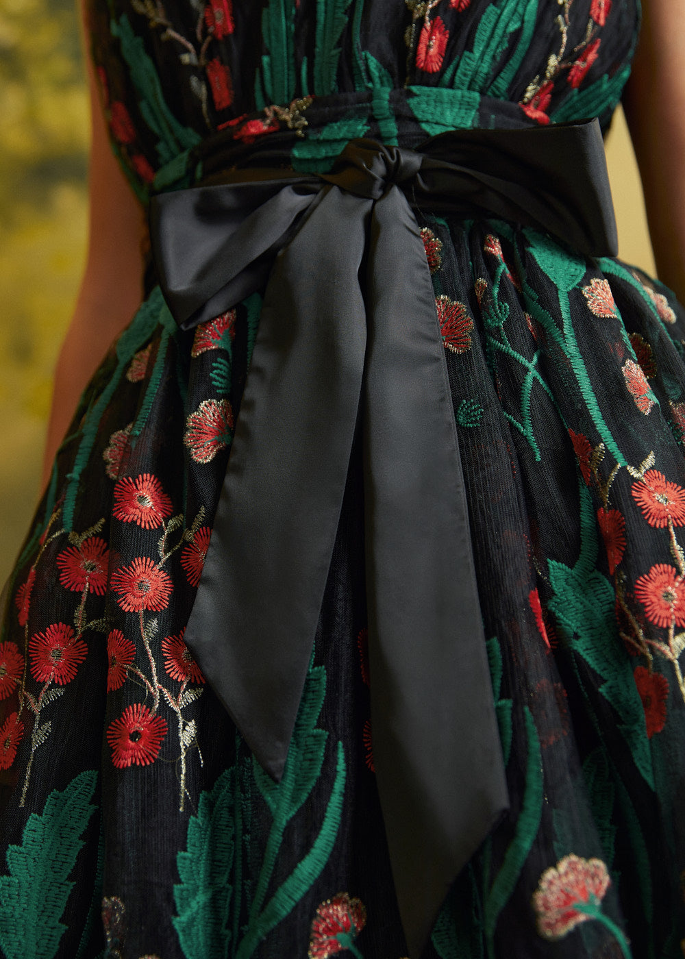 Close-up of the black satin-look waist sash tied into a bow over the embroidered floral mesh of the Memory Lane Fit & Flare Dress.
