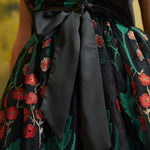 Close-up of the black satin-look waist sash tied into a bow over the embroidered floral mesh of the Memory Lane Fit & Flare Dress.