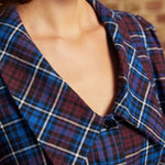 Close-up of the Petal Picnic plaid blouse showing its oversized pointed collar, V-shaped neckline, and functional black buttons in burgundy, blue, and white plaid.