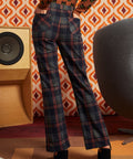 Woman wearing dark navy plaid flare pants with brown cat cardigan and black platform heels, back view showing two patch pockets