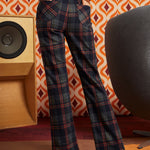 Woman wearing dark navy plaid flare pants with brown cat cardigan and black platform heels, back view showing two patch pockets