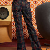 Woman wearing dark navy plaid flare pants with brown cat cardigan and black platform heels, back view showing two patch pockets
