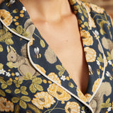 Close-up of the notched collar with cream contrast piping and black button on a vintage-inspired squirrel and floral print dress.