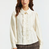 Front view of an ivory long-sleeve blouse with a lace collar, ruffled button front, subtle vertical stripes, and puff sleeves.
