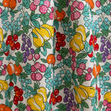 Close-up of a colorful floral and fruit patterned fabric.