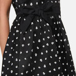 Black dress with white skull pattern and tie waist on a plain background