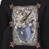 Black sweater with a mermaid graphic design on a plain background