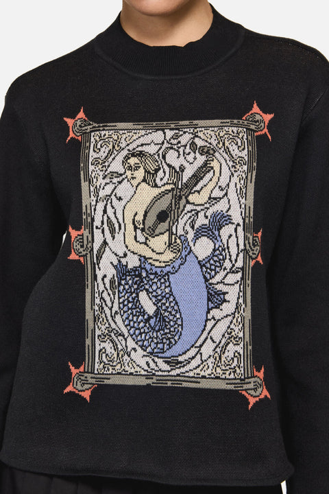 Black sweater with a mermaid graphic design on a plain background