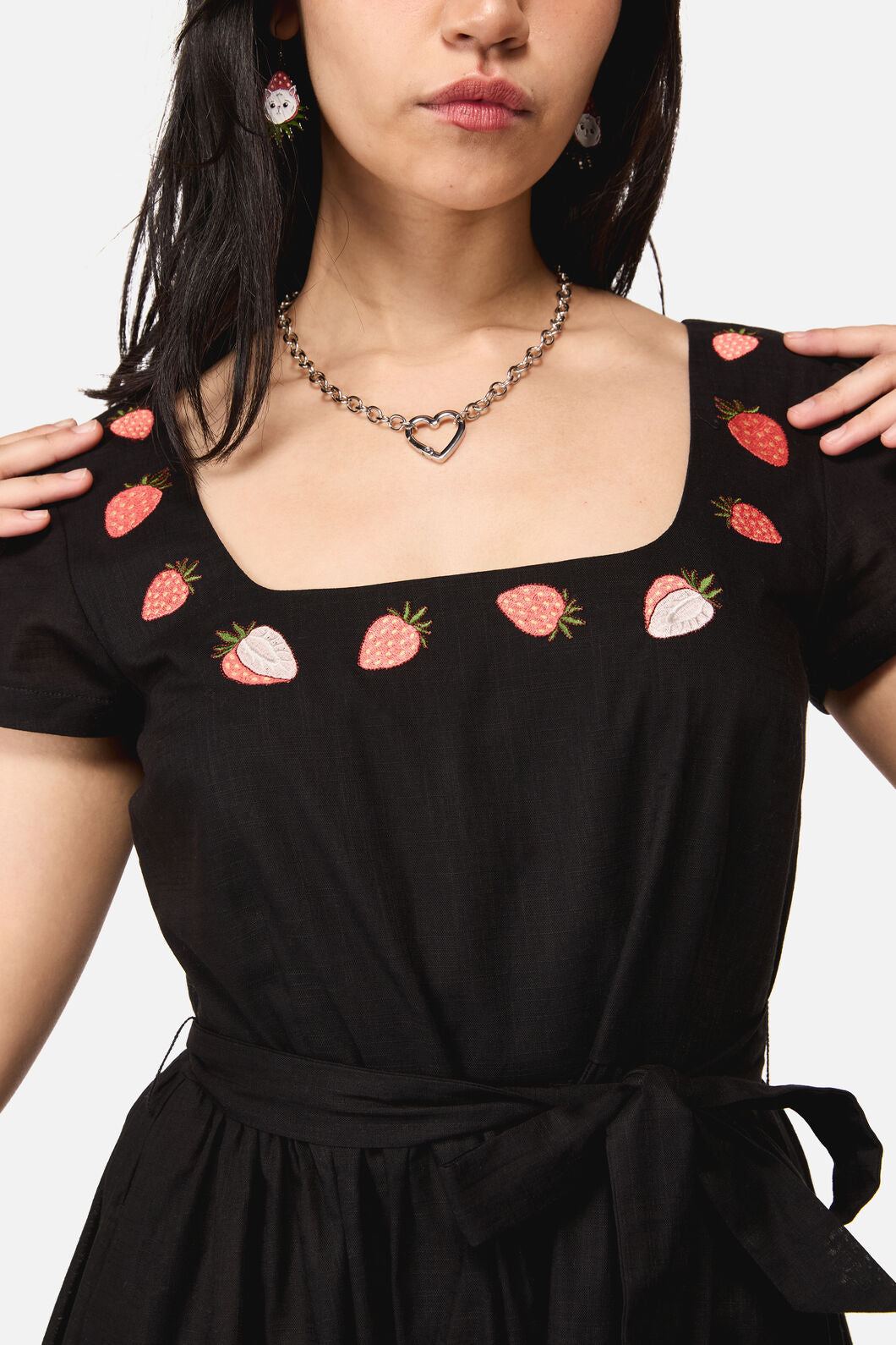 Black dress with strawberry patterns worn by a woman 