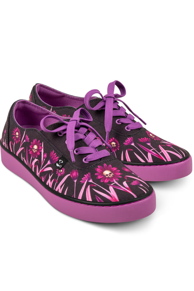 Pair of black sneakers with pink floral and skull designs and purple accents on a white background