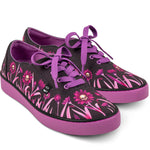 Pair of black sneakers with pink floral and skull designs and purple accents on a white background
