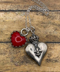 Necklace with a red heart and silver heart-shaped pendant on a wooden surface