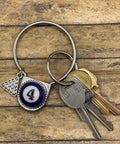 Keychain with number 4 pendant and keys on a wooden surface