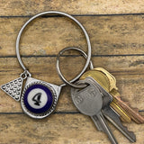 Keychain with number 4 pendant and keys on a wooden surface