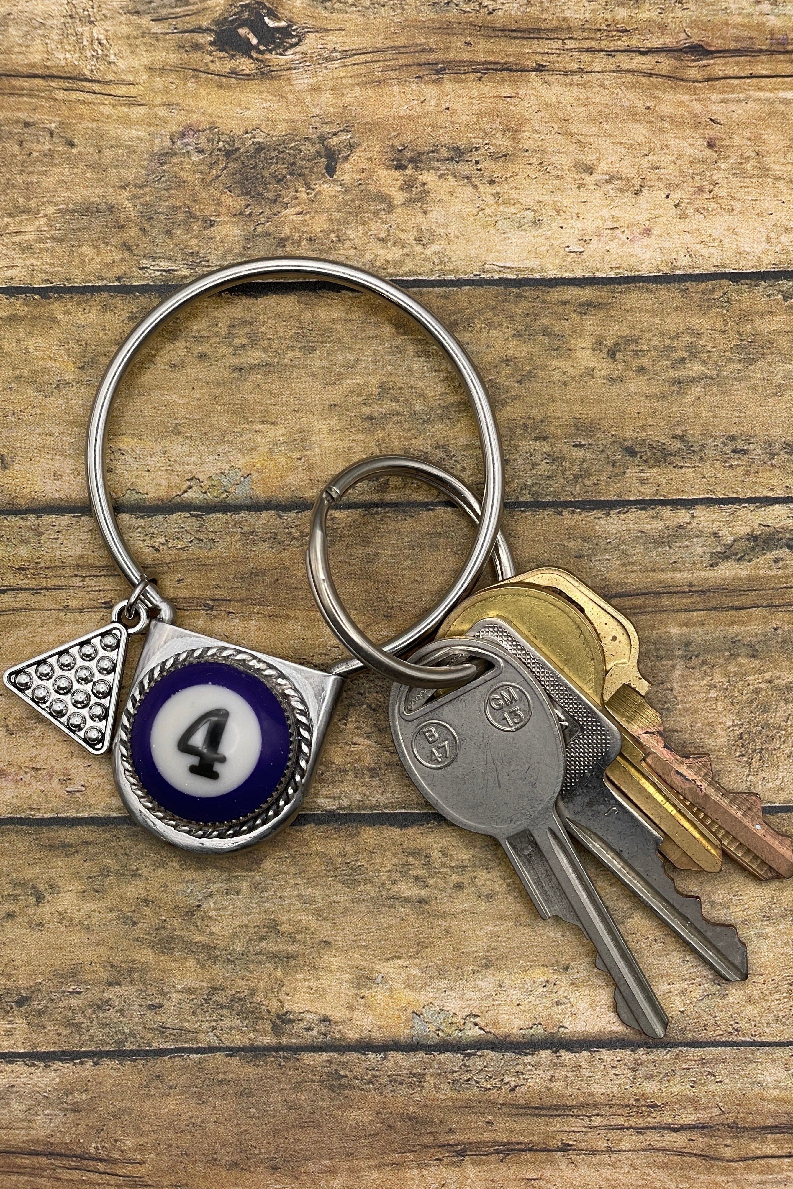 Keychain with number 4 pendant and keys on a wooden surface