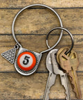 Keychain with billiard ball design and keys on a wooden surface