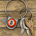 Keychain with billiard ball design and keys on a wooden surface