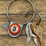 Keychain with billiard ball design and keys on a wooden surface