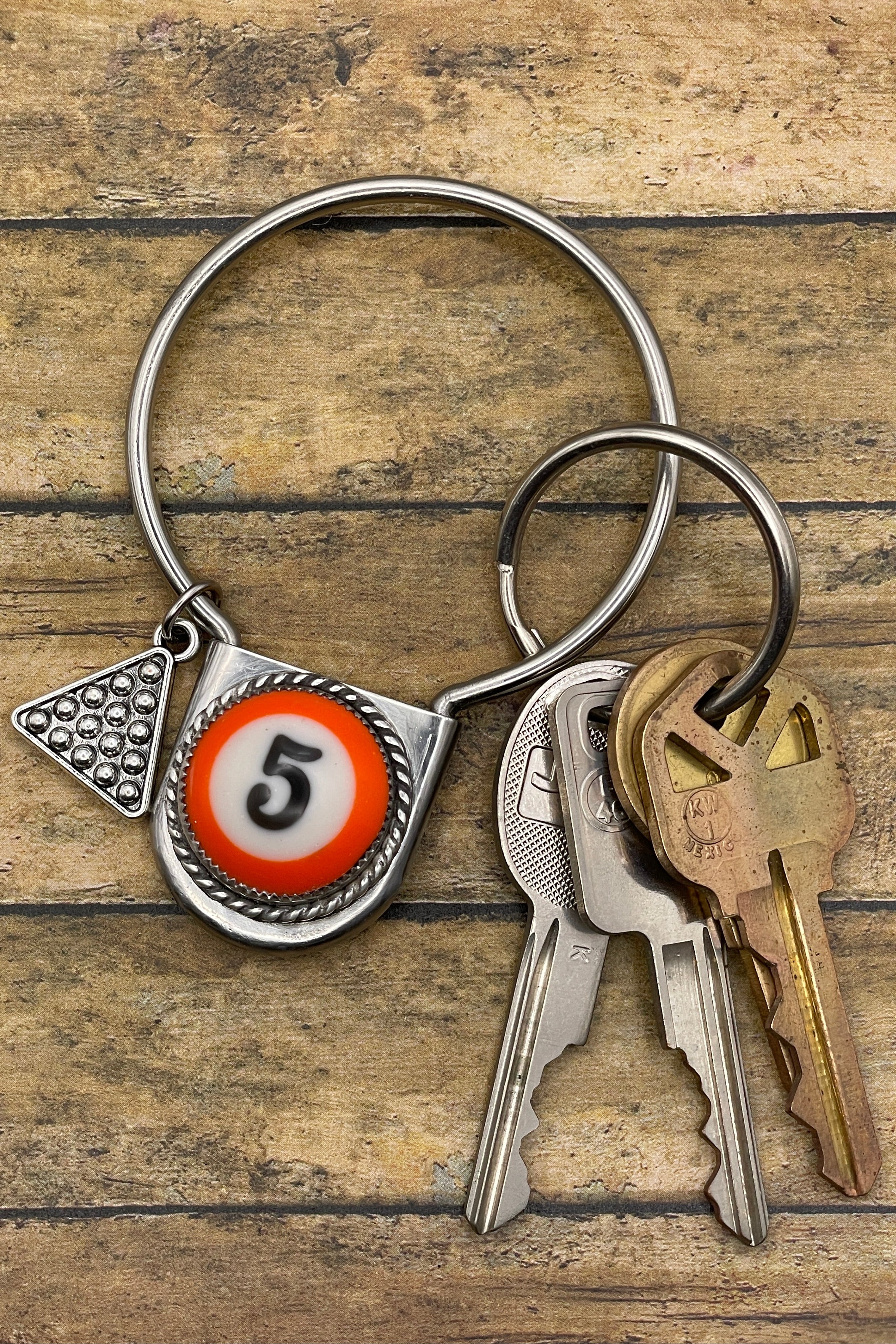 Keychain with billiard ball design and keys on a wooden surface
