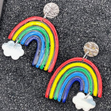 Colorful rainbow-shaped earrings with cloud designs on a black background