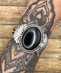 Artisan made sterling silver cuff bracelet with large black onyx center stone and fan detail on sides.