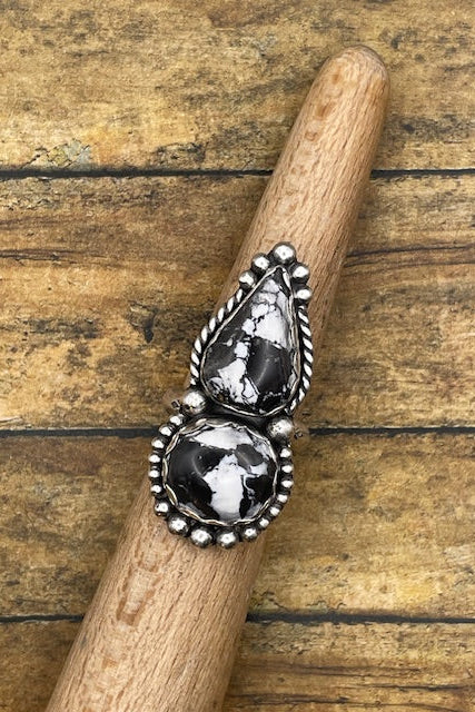 Silver ring with black stones on a wooden stick