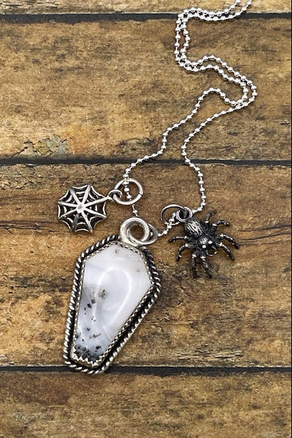 Artisan made sterling silver necklace with a coffin shaped pendant featuring a spider and web charms