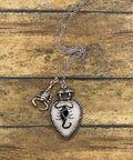 Necklace with a scorpion pendant on a wooden surface