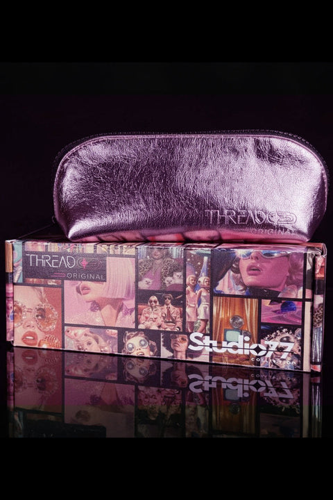 Pink makeup pouch on top of a box with 'Thread Original' branding, against a black background