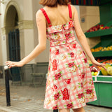 Back view of a woman in a pink floral dress with red adjustable straps.
