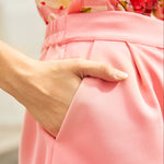 Close-up of a woman wearing pink shorts with pockets