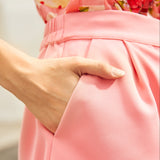 Close-up of a woman wearing pink shorts with pockets