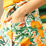 Woman wearing a colorful outfit with an orange fruit pattern