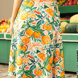 Woman wearing a skirt with a colorful fruit pattern in front of a fruit stand.