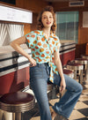 Woman in patterned mint and coral wrap top
