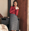Woman in red sweater and patterned skirt