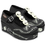 Black platform shoes with skeleton design and skull embellishments on a white background