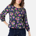 Woman wearing a navy blue top with fruit pattern on a white background