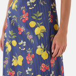 Navy blue skirt with colorful fruit pattern worn by a woman