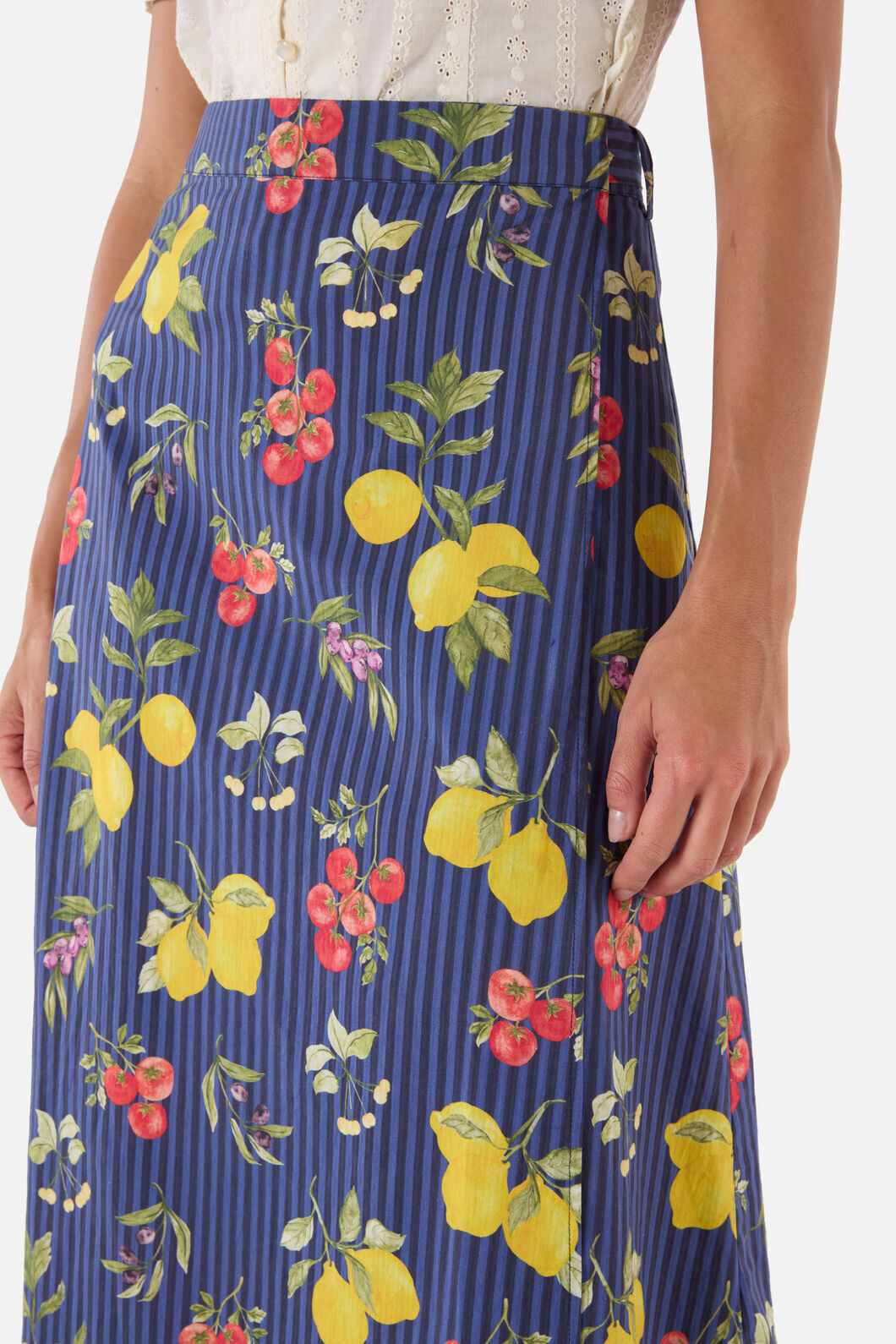 Navy blue skirt with colorful fruit pattern worn by a woman
