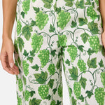 Pants with green grapevine pattern on a white background