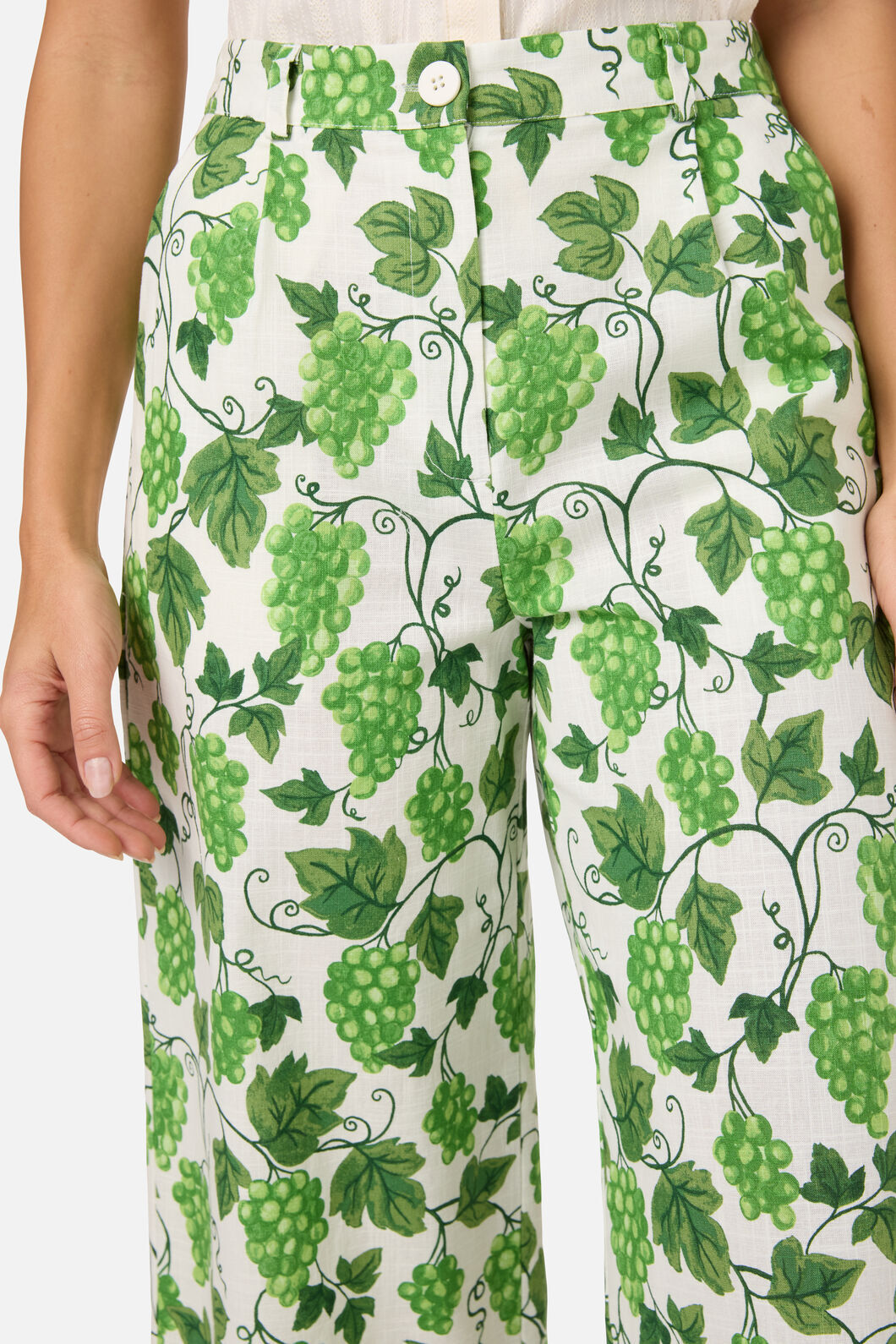 Pants with green grapevine pattern on a white background