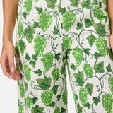Pants with green grapevine pattern on a white background