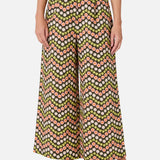 Person wearing a patterned wide-leg pants on a white background