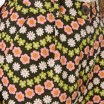 Floral patterned pants with a button detail on a dark background
