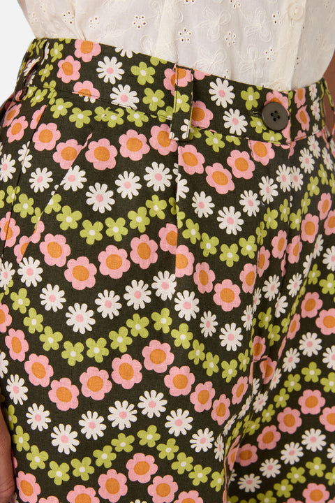 Floral patterned pants with a button detail on a dark background